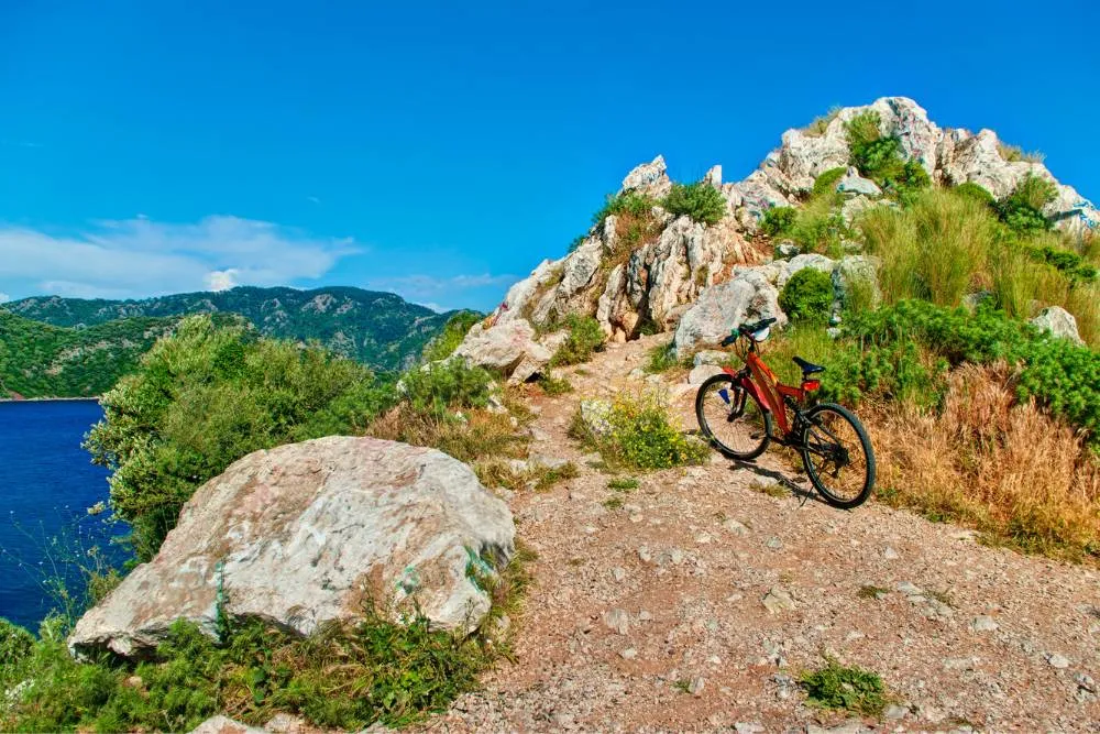 Mountain bike on cliff in the sun — Getty Images