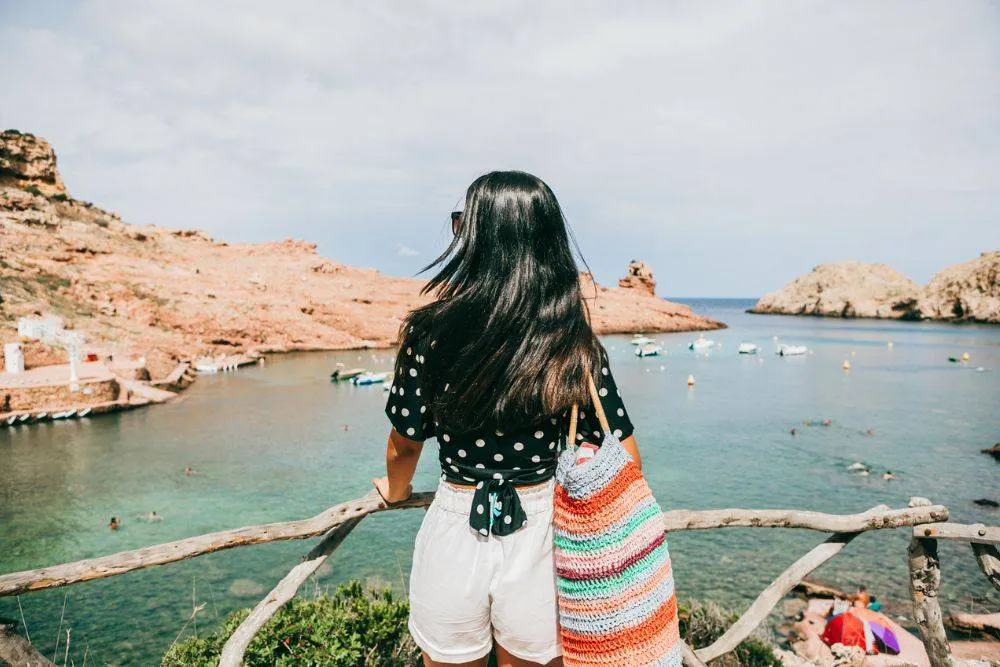 woman standing in from of Cala Morell enjoying the view, Minorca,Balearic islands