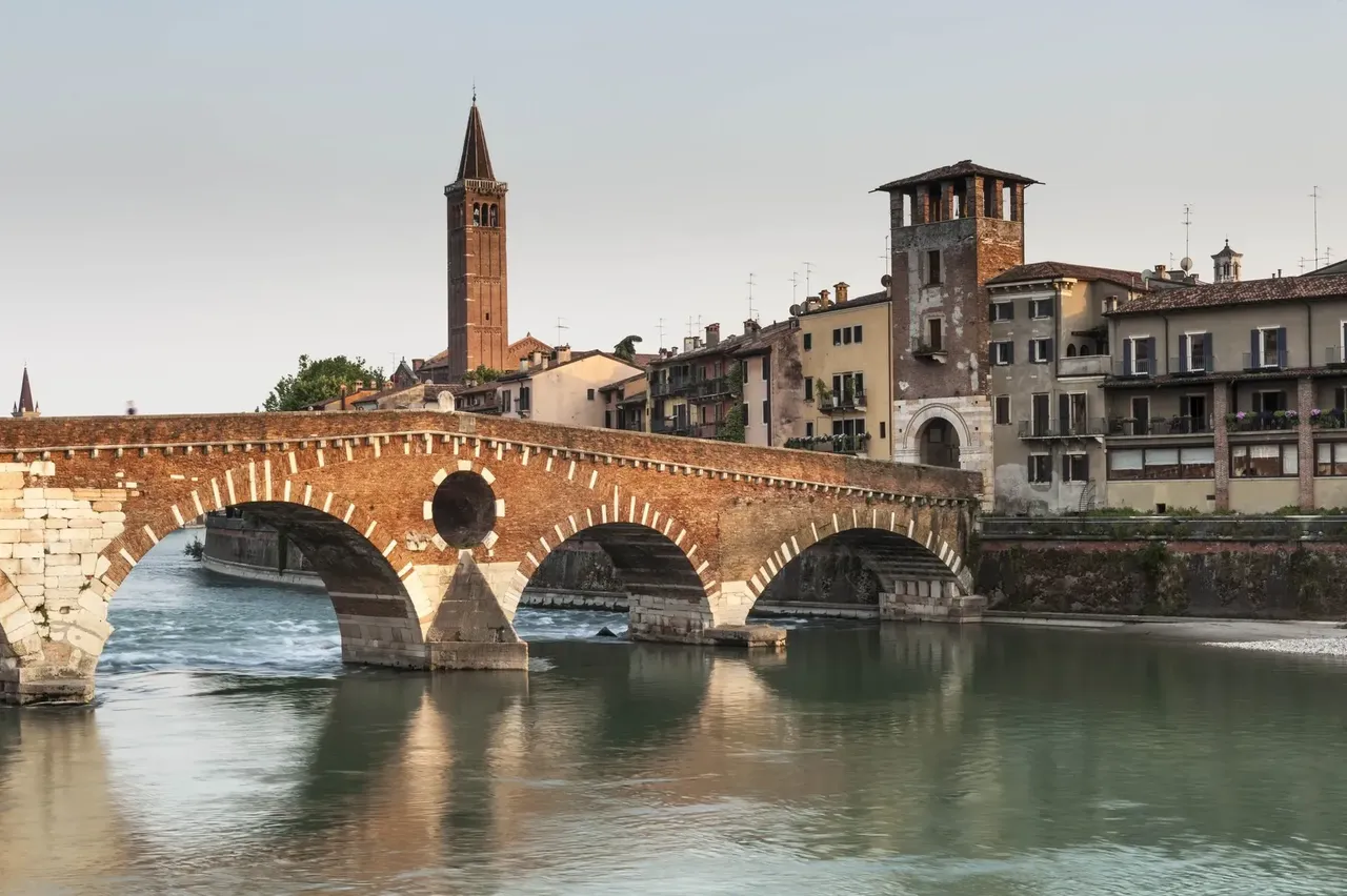 Az ókori római időkből származó Ponte Pietra híd Veronában, amely időtlen bájjal ível át az Adige folyón.