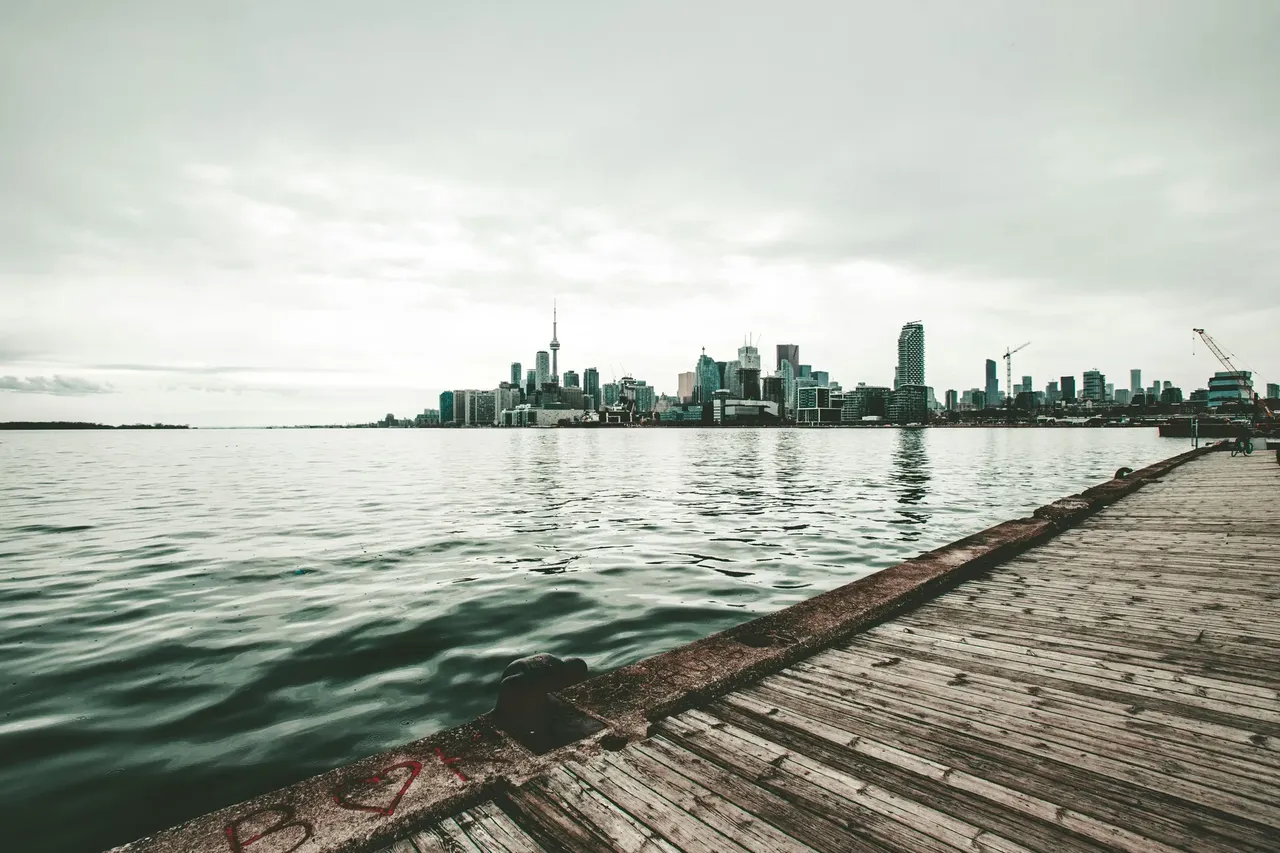 The CN Tower standing tall next to the shimmering waters of Lake Ontario