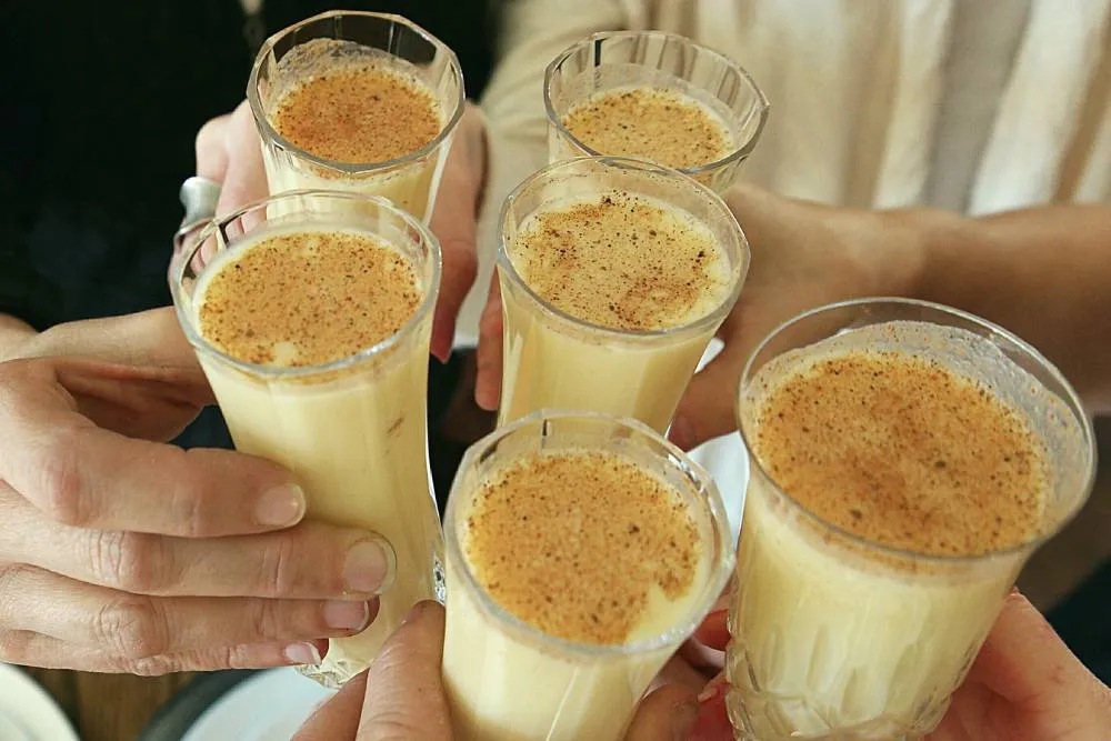 People toasting with glasses of eggnog — Getty Images
