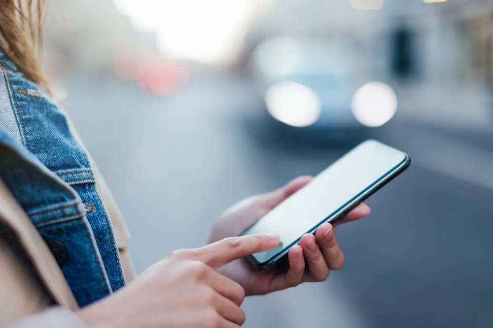Close-up of person holding phone outside — Getty Images
