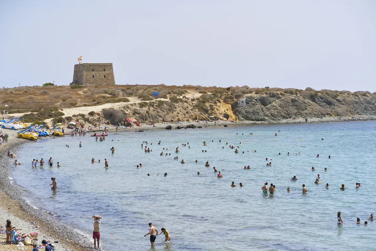 un grup de oameni pe plaja insulei Tabarca, bucurându-se de o vacanță în marea din Alicante