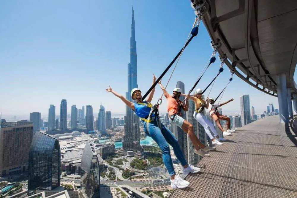 People atop skyscraper in Dubai on harnesses for the Dubai Sky Views experience — Visit Dubai