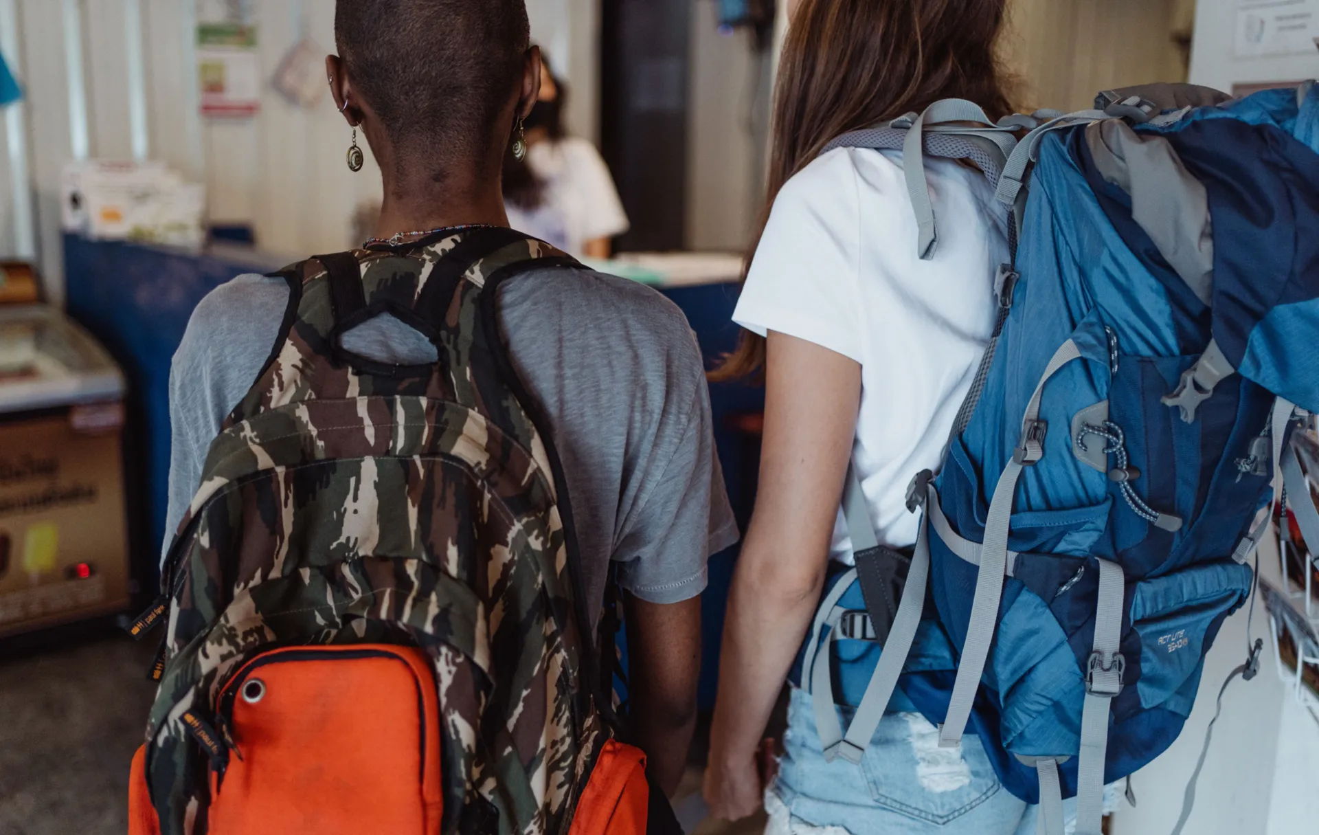 Two travelers waiting with large backpacks