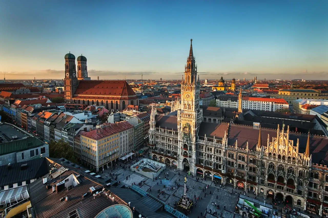 A wide aerial view of Munich, Germany, featuring a mix of modern and historic buildings