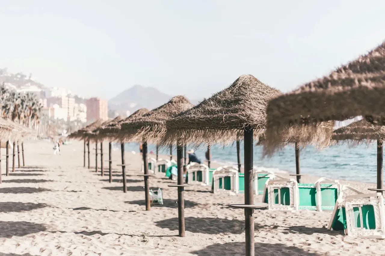 La Malagueta beach, with golden sands and calm waves, stretches along the coastline of Malaga.