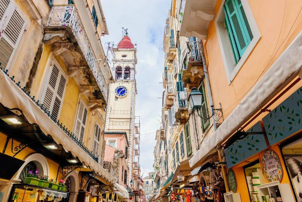 Narrow shopping street and St. Spyridon Church bell tower in Corfu Town — Getty Images