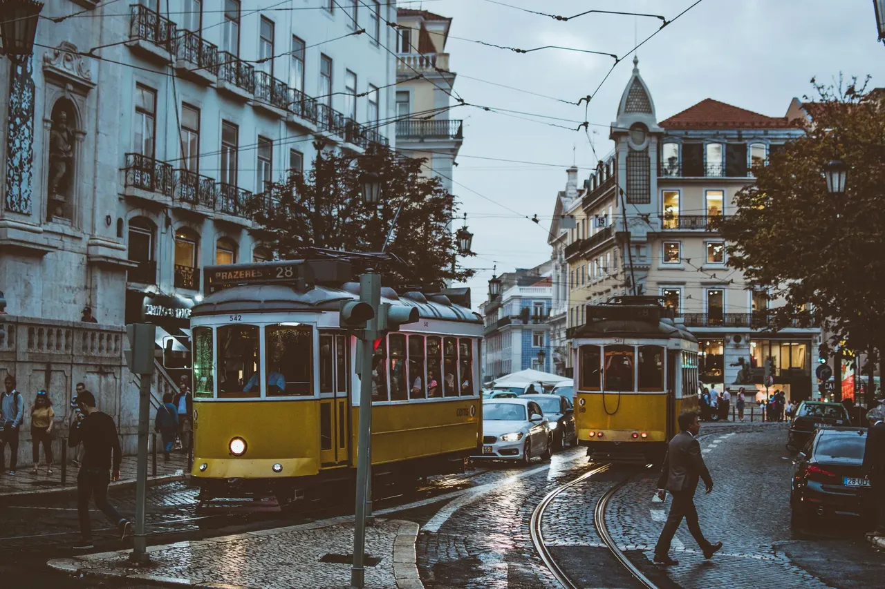 Iconic yellow trams in Lisbon traveling along praça Luis de Camoes