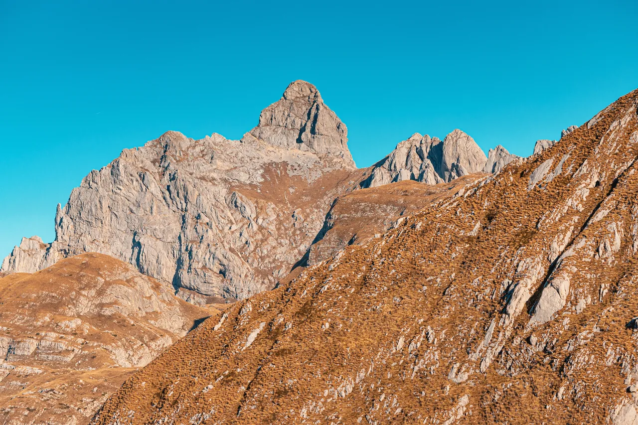Impressive Bobotov Kuk peak and rock formation dominates the Durmitor landscape under a vibrant blue sky, showcasing the raw beauty of nature