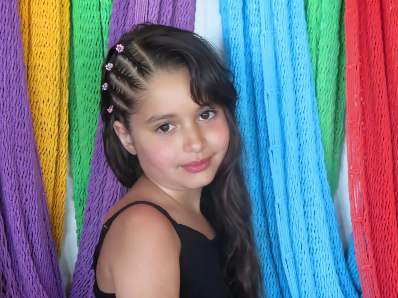 Portrait of 6 years old girl showing off her braided hair with pride.