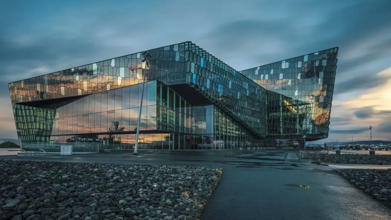 A Harpa koncertterem modern üveghomlokzatán tükröződnek az izlandi naplemente színei – valódi építészeti mestermű