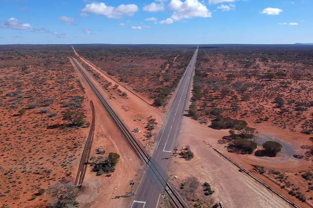 The Ghan railway line crossing the Stuart Highway in the outback — Shutterstock