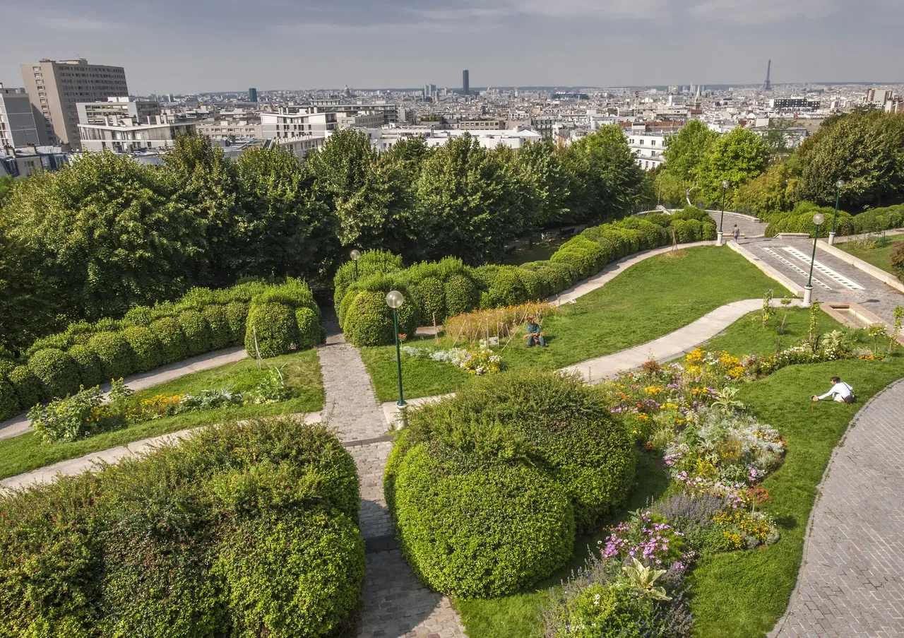 A picturesque scene from Parc de Belleville, with a clear view of the Eiffel Tower in the distance, framed by lush greenery.