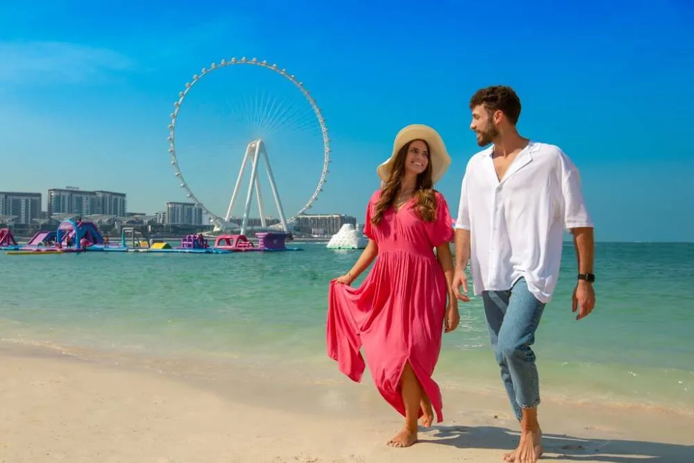 Couple at The Beach in Dubai with ferris wheel in background — Visit Dubai