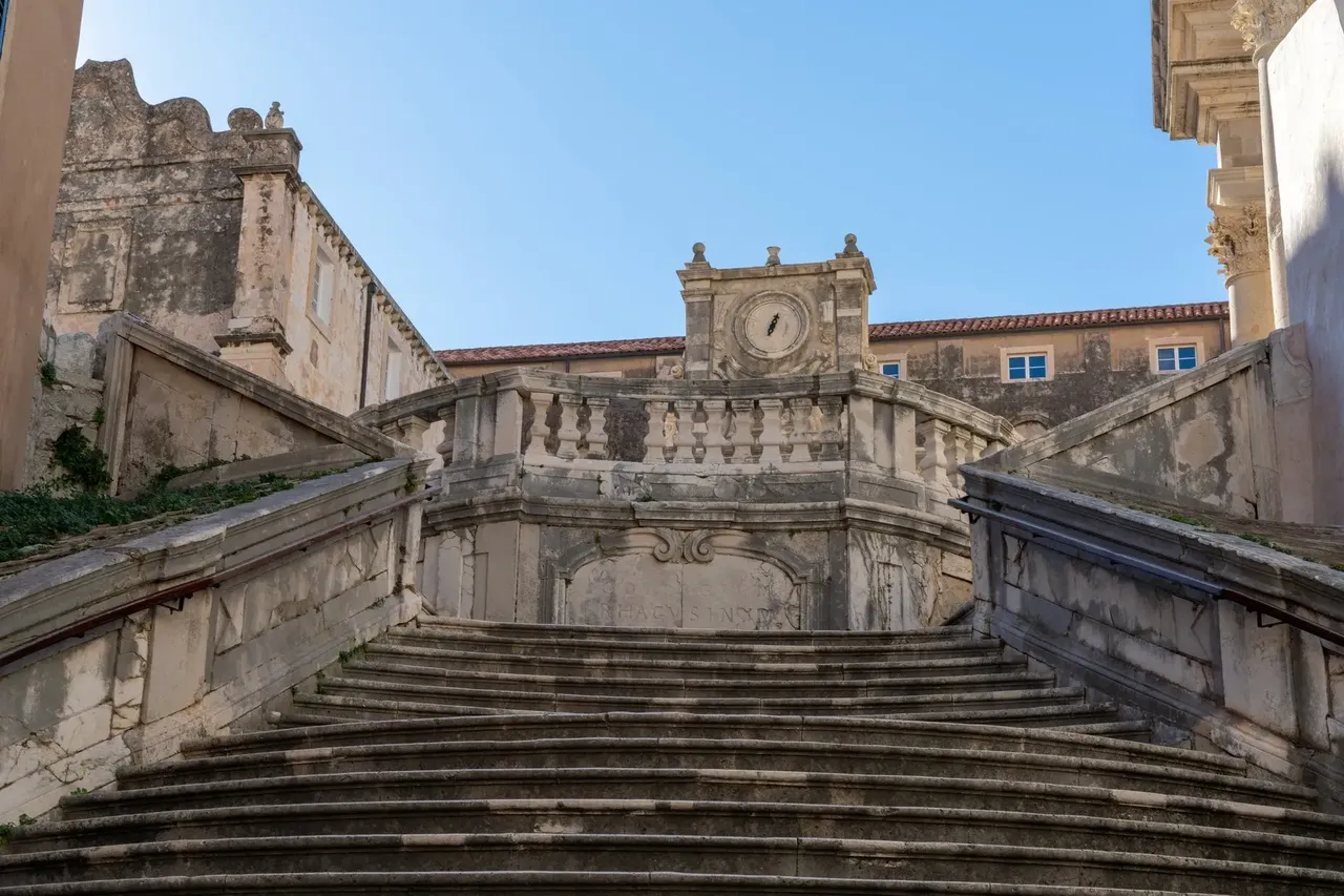 Velké schodiště ve Starém městě v Dubrovníku, známé ze seriálu Hra o trůny, s historickými hodinami a ozdobnými kamennými balustrádami