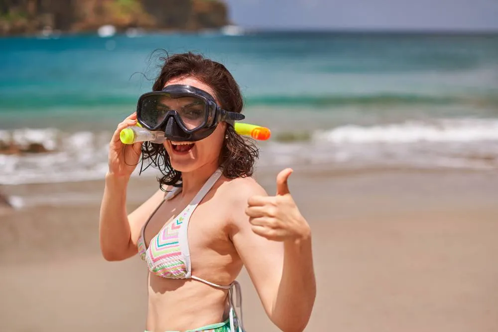 Woman on beach with snorkel — Getty Images