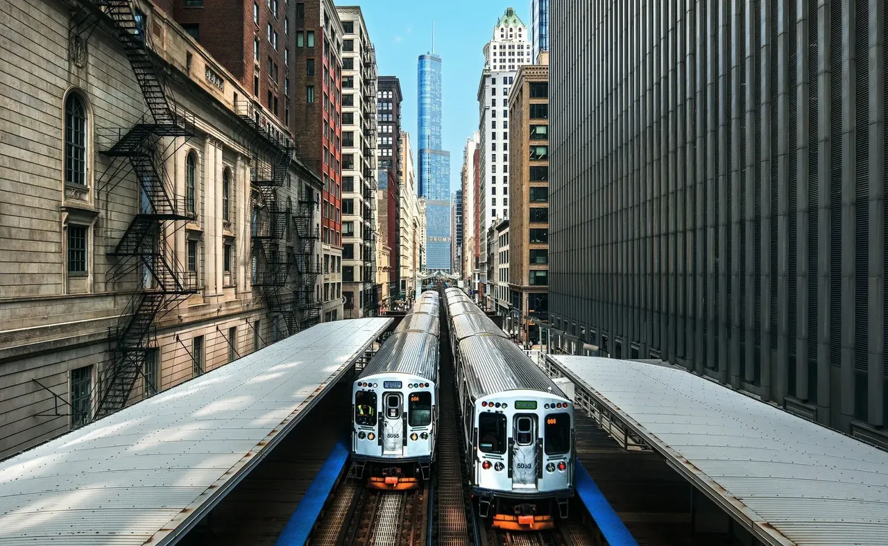 Záběr na slavné nadzemní metro v Chicagu projíždějící městskou zástavbou.