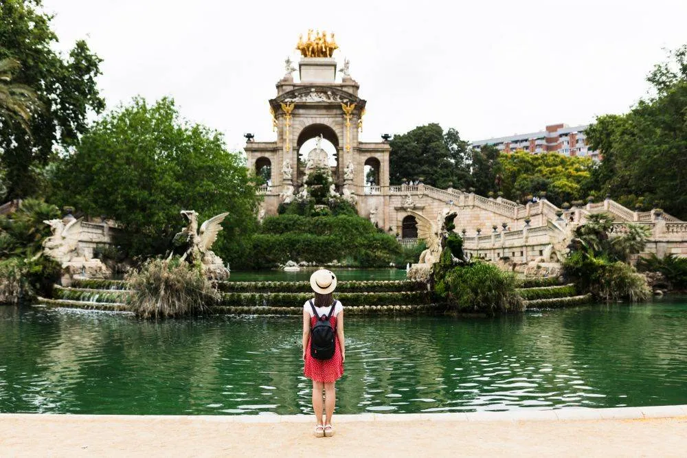 Egy turista a Ciutadella Parkban Barcelonában - Divatos turista hátizsákkal a hátán.