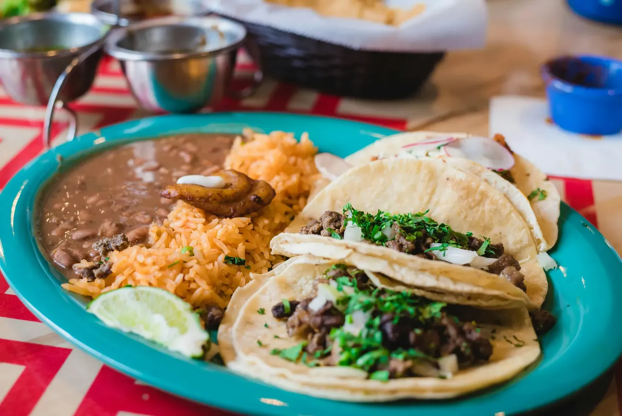 Close-up of a plate of tacos from Gringos Locos in Orlando, showcasing soft tortillas filled with seasoned meat, fresh toppings, and vibrant salsa.