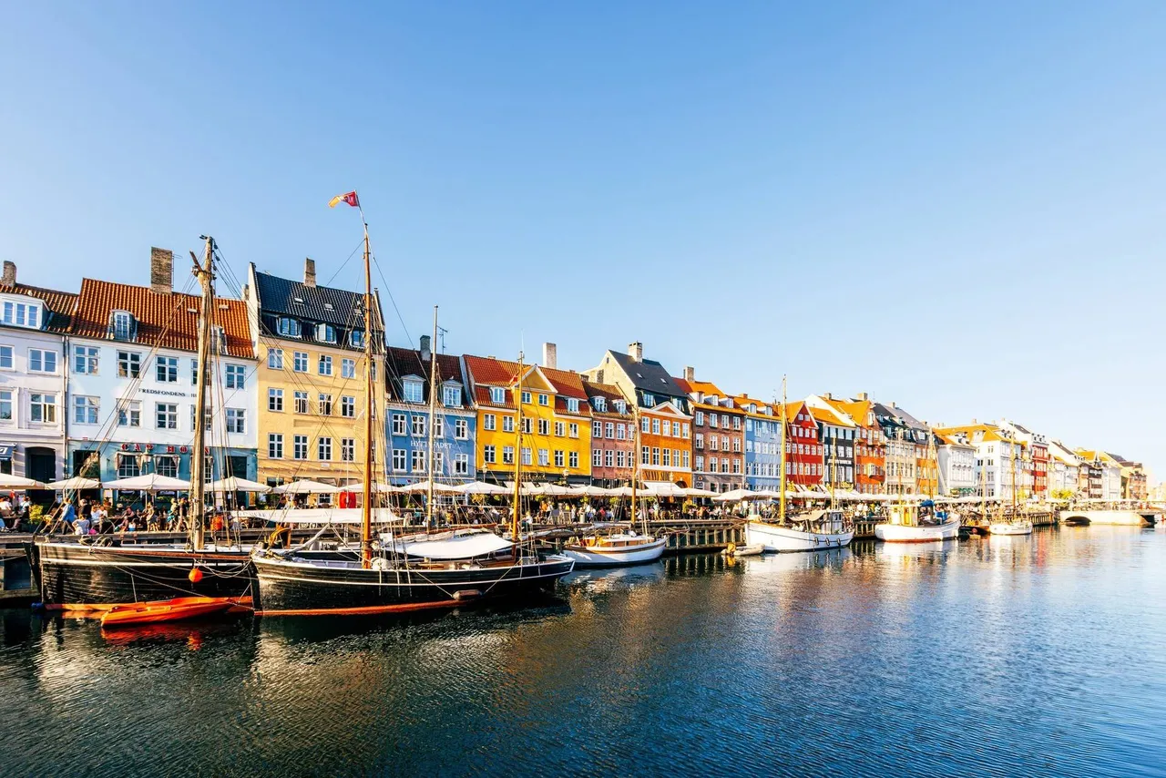 Pestrobarevné domy v přístavu Nyhavn za slunečného letního dne s jasnou modrou oblohou, Kodaň, Dánsko