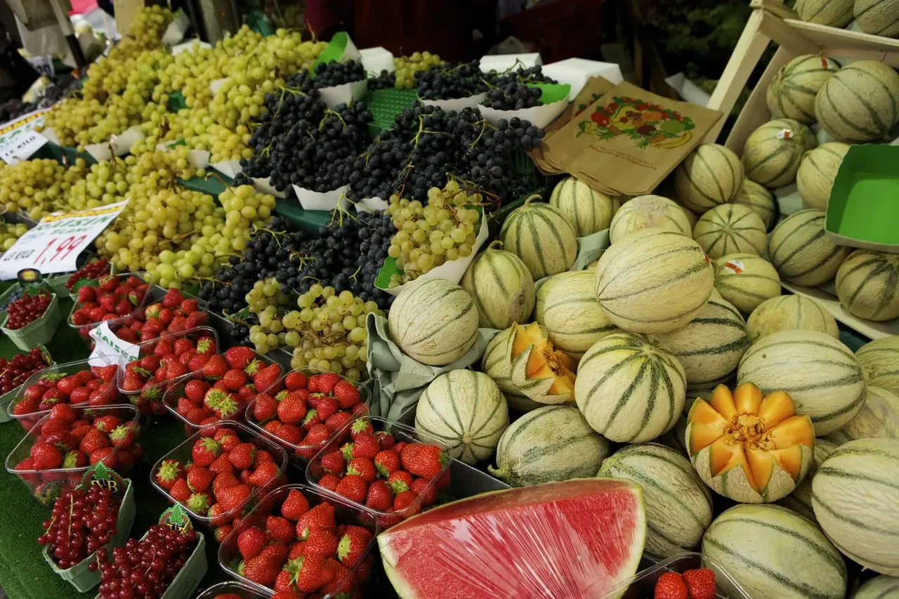 A vibrant display of fresh fruits at a market in Belleville, with colorful produce like oranges, apples, and berries.