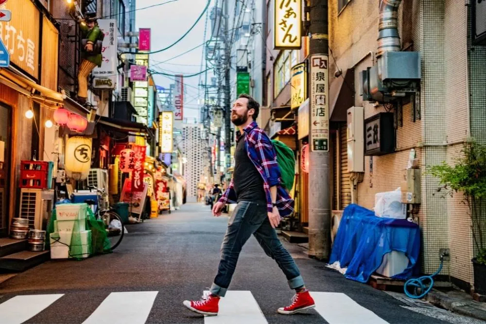 Tourist walking alone across zebra crossing in Tokyo — iStock