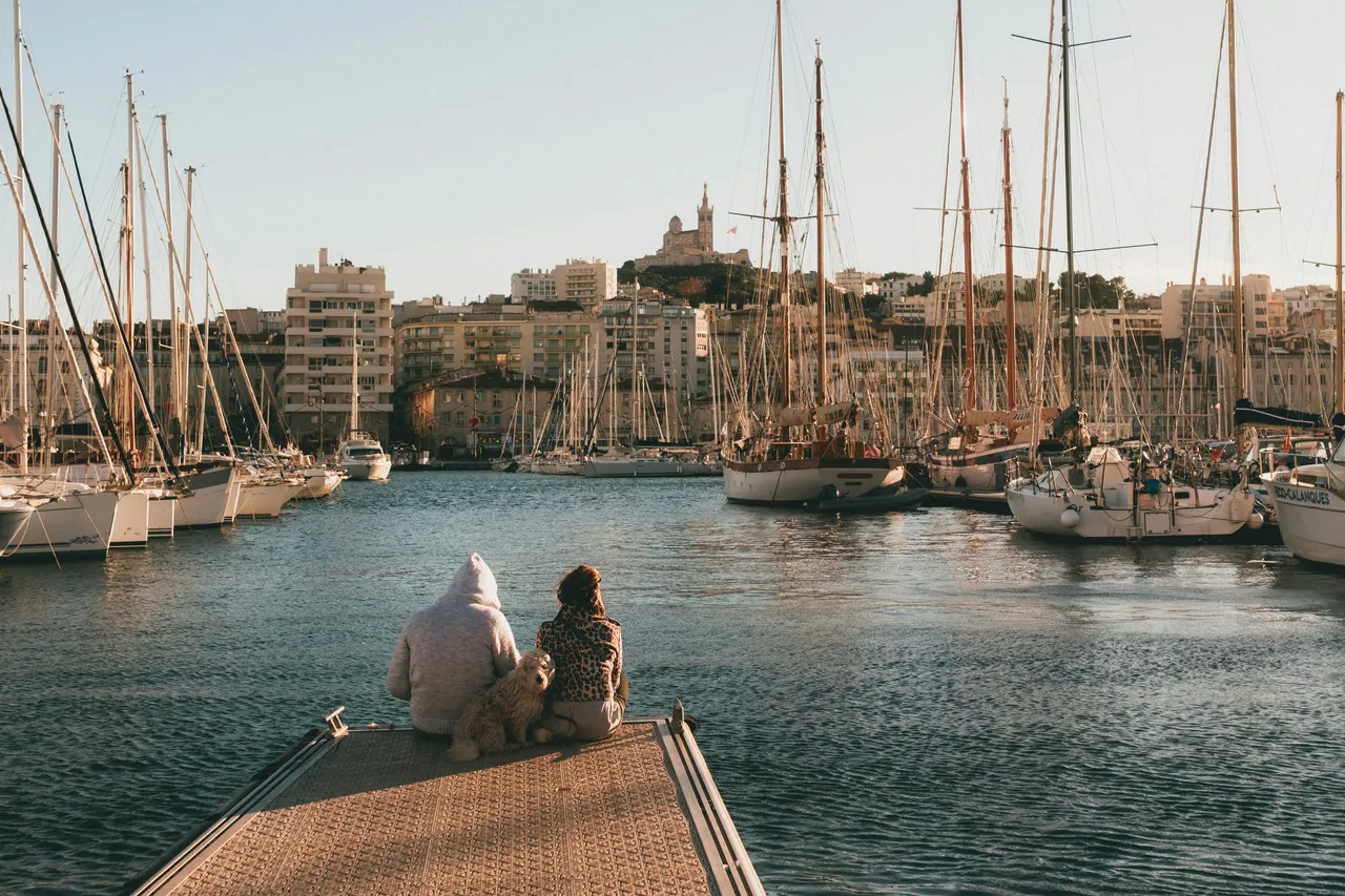 a couple and their dog sitting by the Marseille port