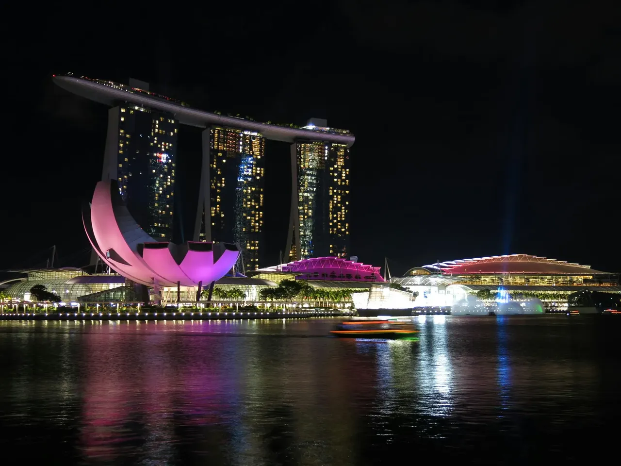 The Marina Bay Sands hotel and vibrant city lights reflecting over the waters of Singapore at night