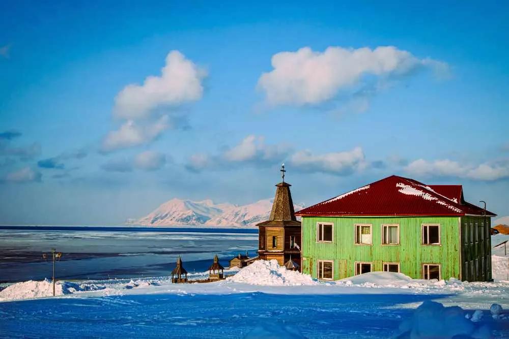 Zielony drewniany budynek w zimowym krajobrazie na Svalbard.