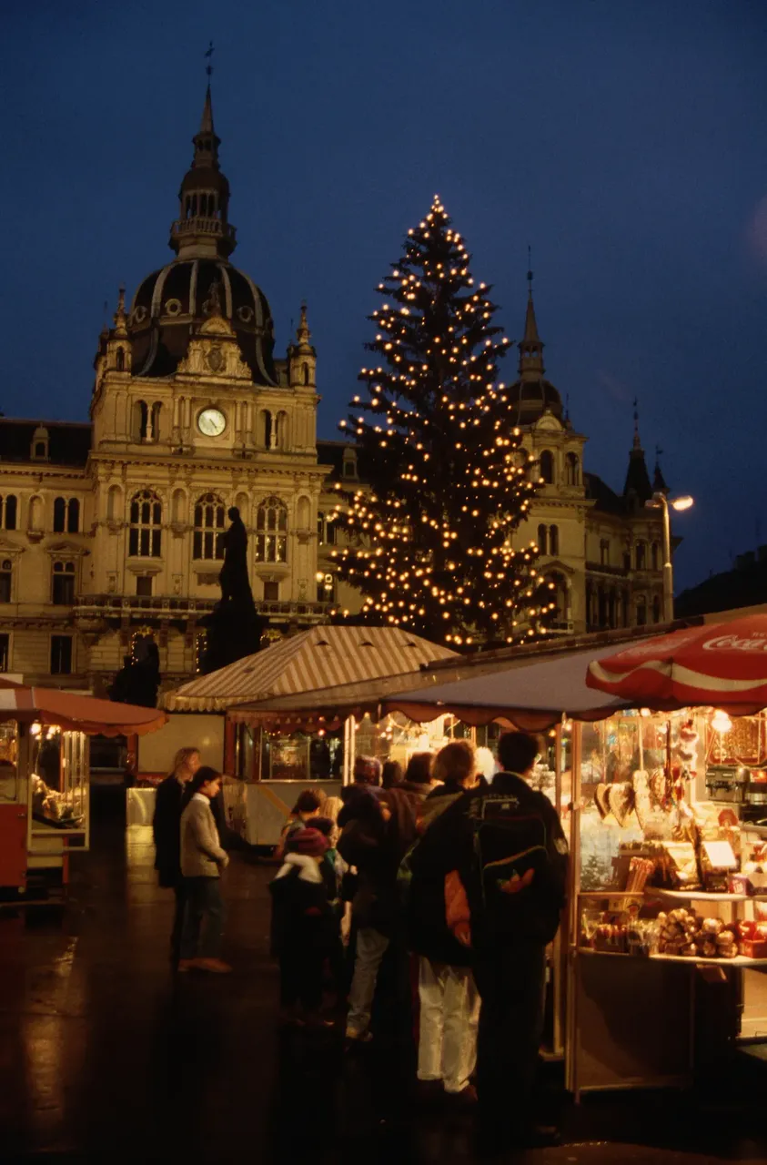 Festive Christmas market in Graz, Austria, with twinkling lights and traditional wooden stalls offering holiday treats