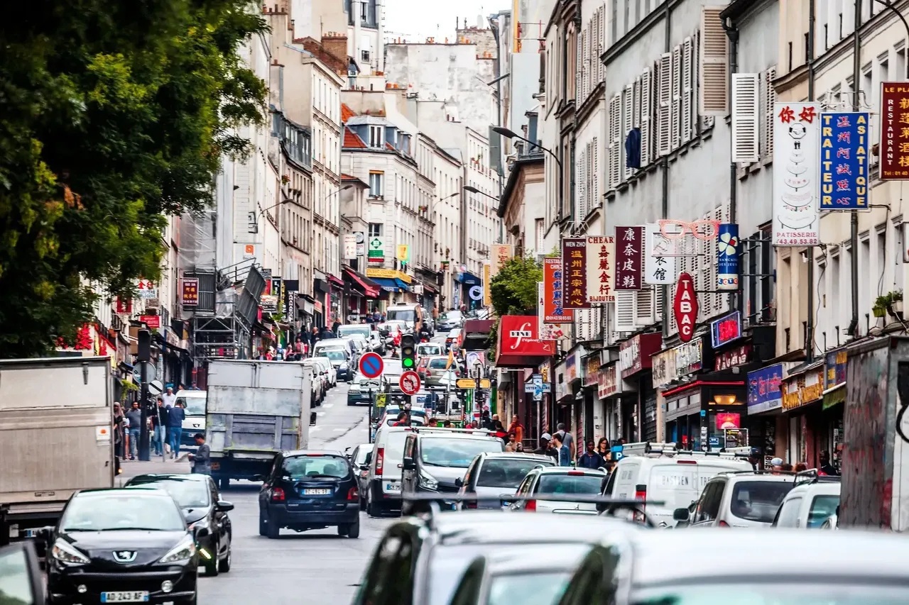 A bustling street in Belleville filled with people and vehicles, showcasing the lively atmosphere of the neighborhood.
