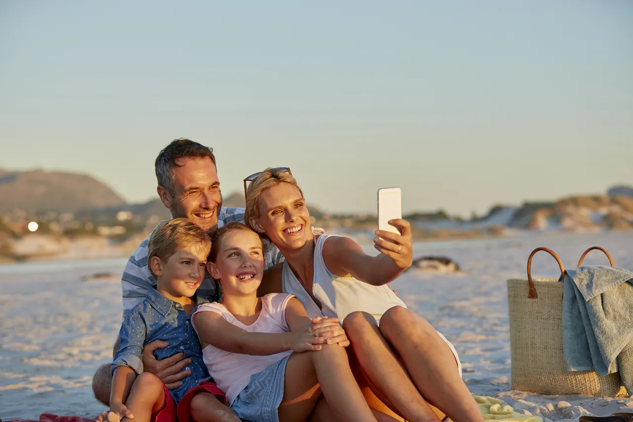 Family with two children taking a family selfie on a beach holiday, Mexico