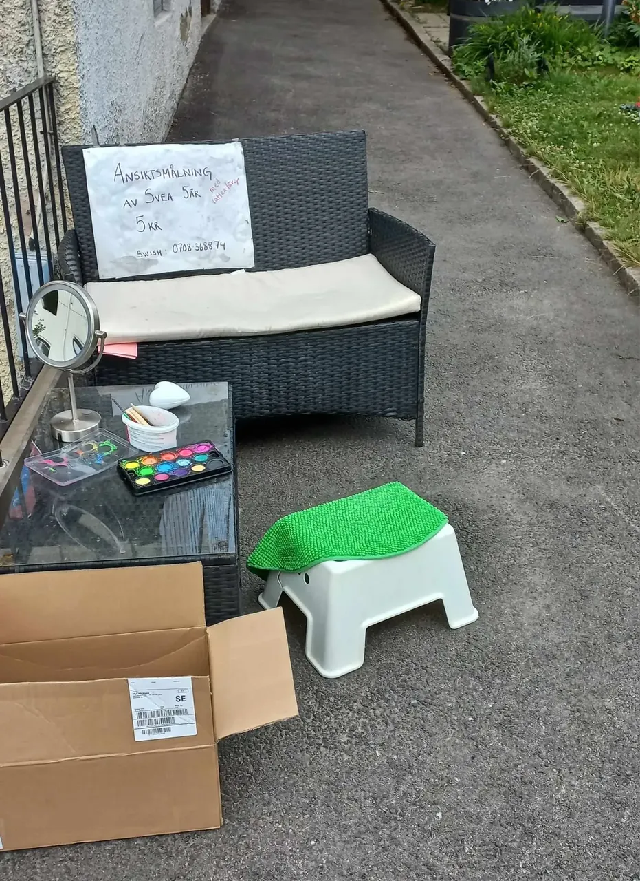 Child’s makeshift face-painting stall on footpath — David Szmidt
