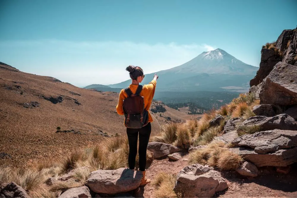 Woman pointing at Popocatépetl volcano — Getty Images
