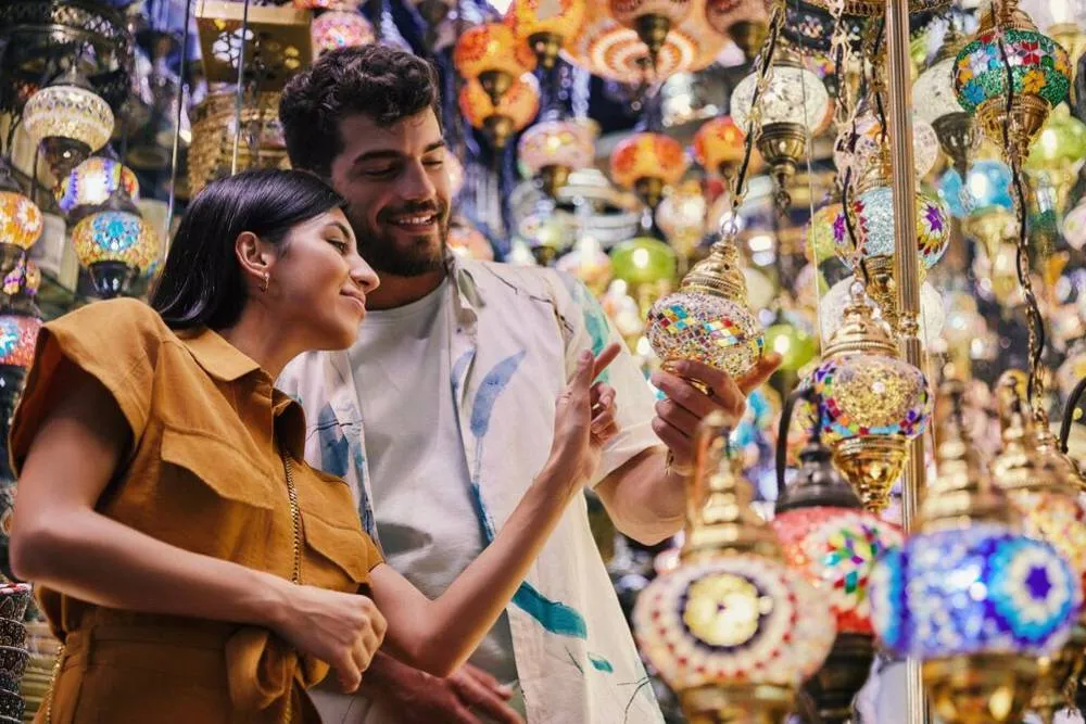 Couple looking at traditional lanterns at traditional Emirati market — Visit Dubai