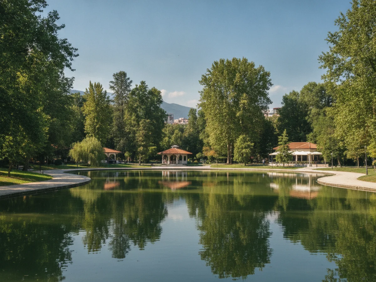 The Grand Park of Tirana with its artificial lake, walking paths and trees reflected in still water on a sunny day