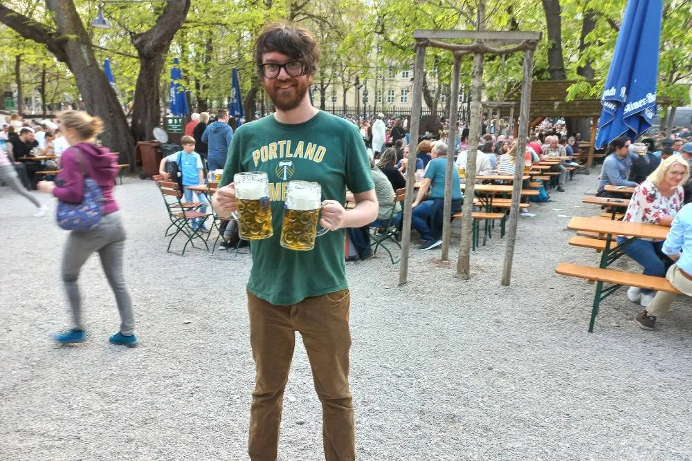 David holding two beers in beer garden in Munich — David Szmidt