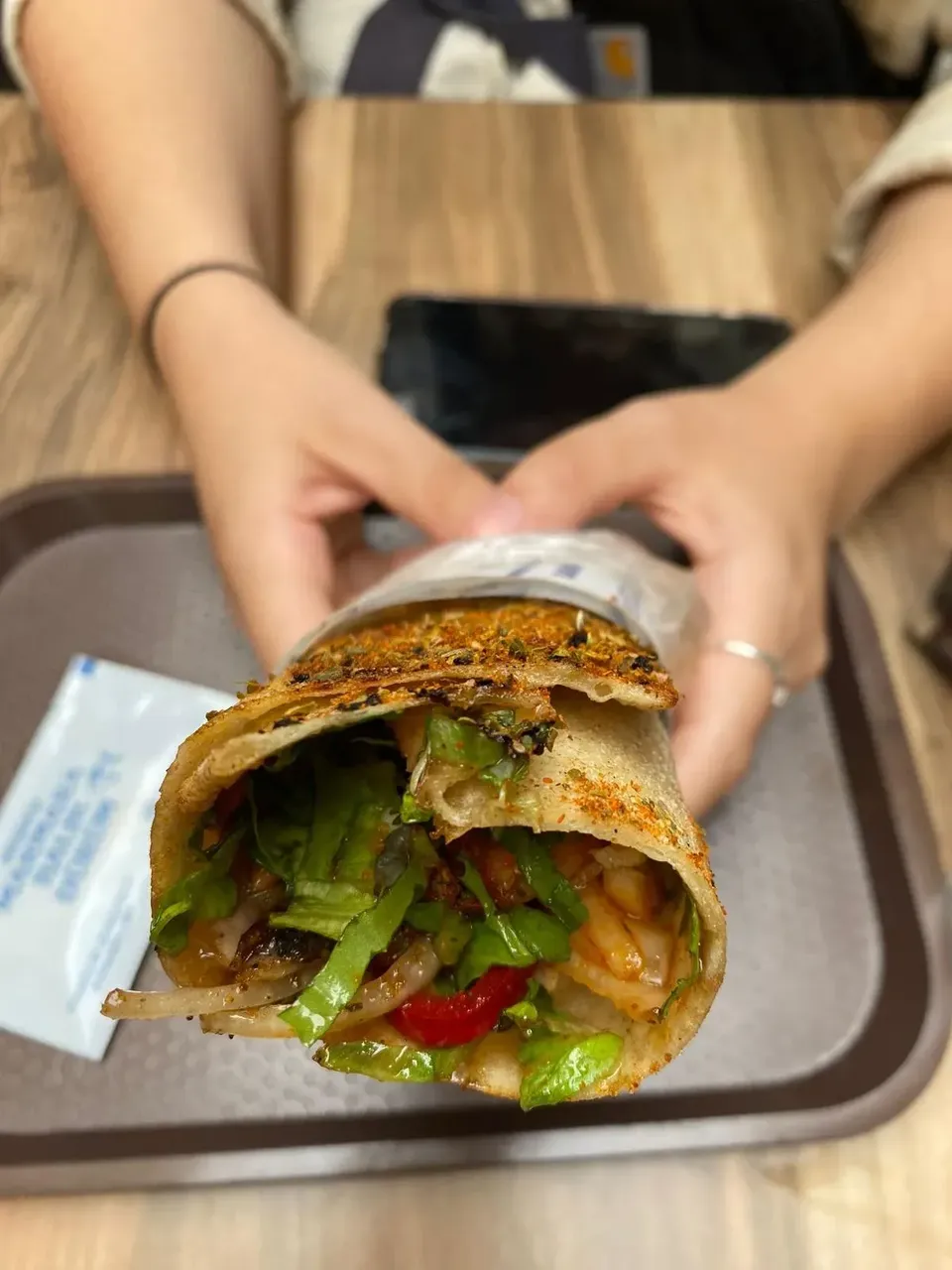 A freshly made Turkish fish wrap, known as balik ekmek, with grilled fish fillet, crisp lettuce, onions, and tomatoes wrapped in a soft flatbread.
