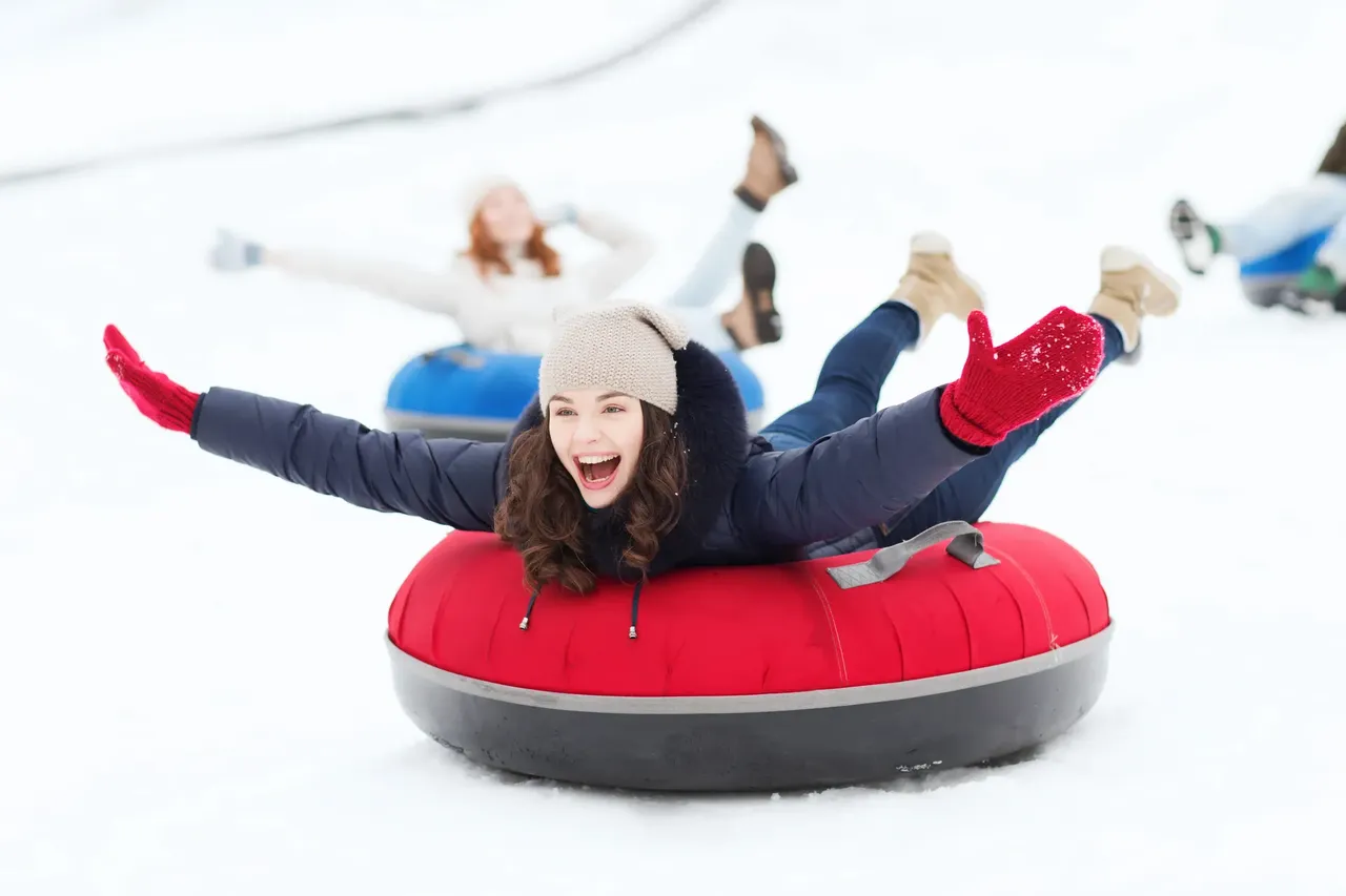 Woman snow tubing — Shutterstock