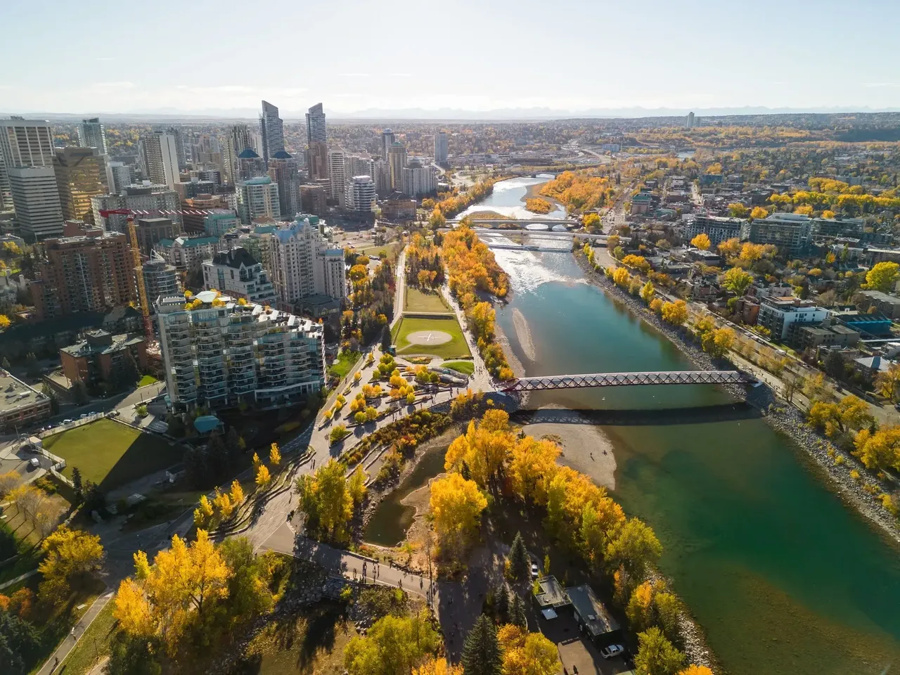 Prince’s Island Park Peace Bridge autumn foliage scenery. Aerial view of Downtown City of Calgary. Alberta, Canada.