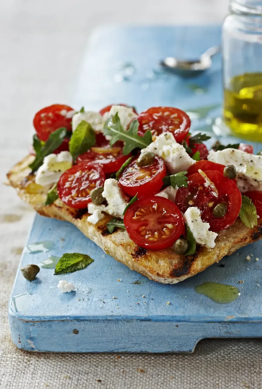 Egy tányérnyi hagyományos olasz bruschetta friss paradicsommal, bazsalikommal és olívaolajjal.