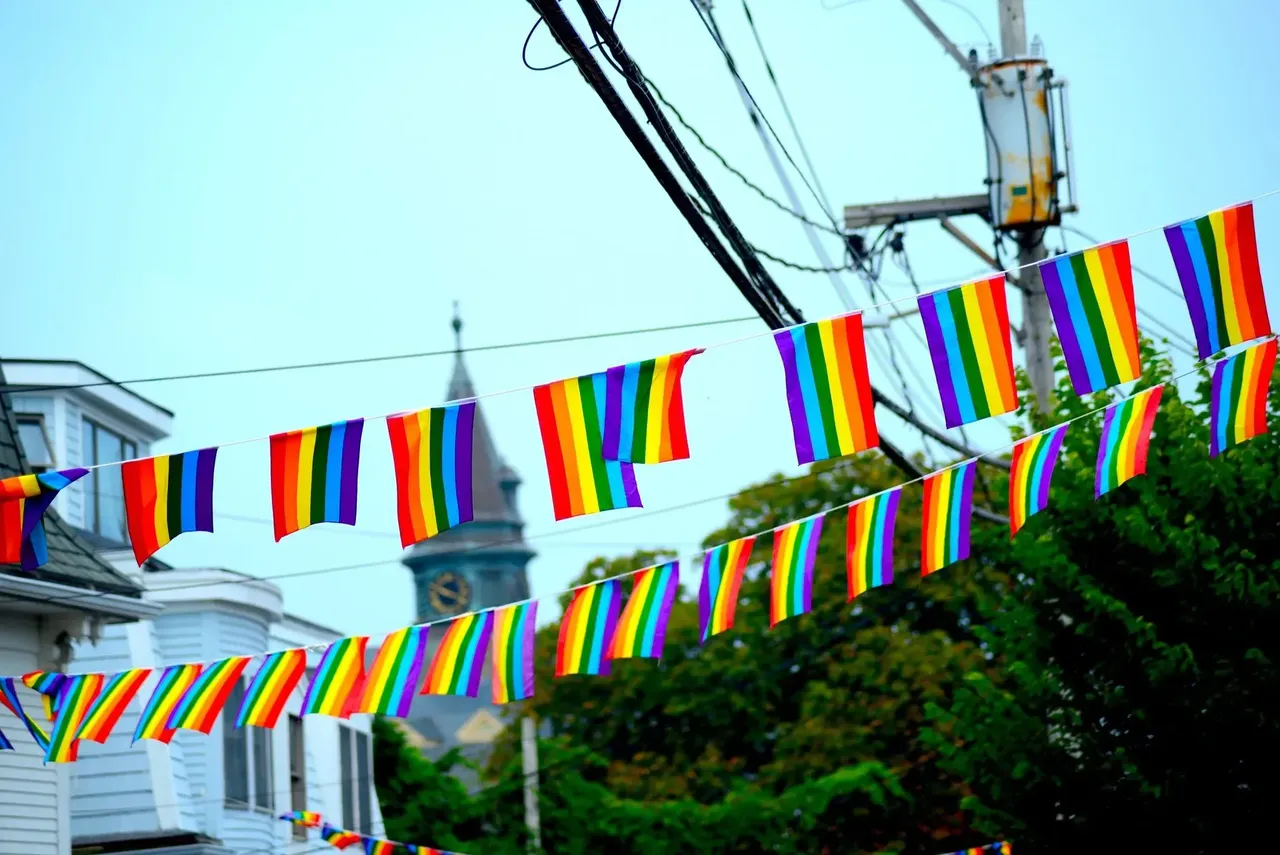 A város aktív és befogadó LMBT-közösségét jelképező szivárványos zászlók a provincetowni Commercial Street épületei mentén
