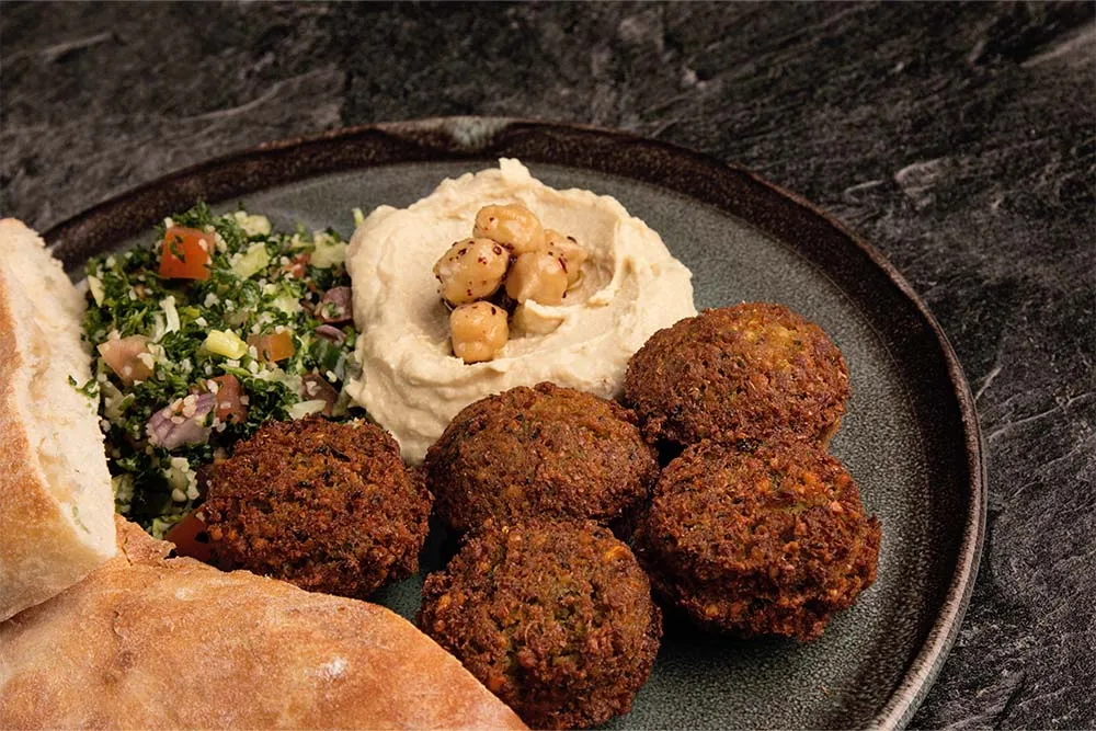 Plate of falafel, hummus and couscous salsa — Shutterstock