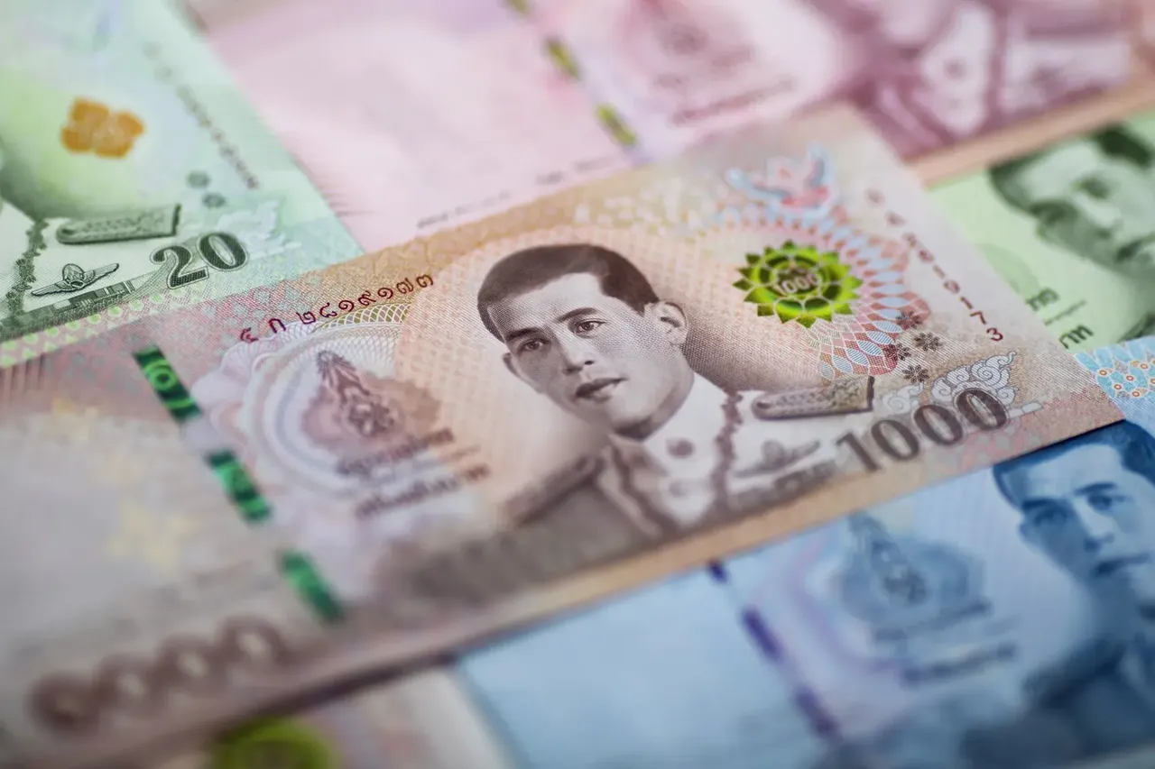 A close-up shot of Thai baht banknotes, highlighting the intricate designs, vibrant colors, and the portrait of the Thai king.