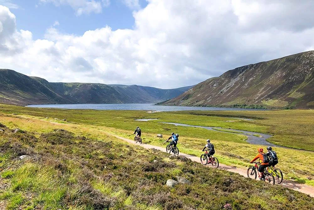 Cyclists near a lake in Lochnagar mountain, Scotland, United Kingdom