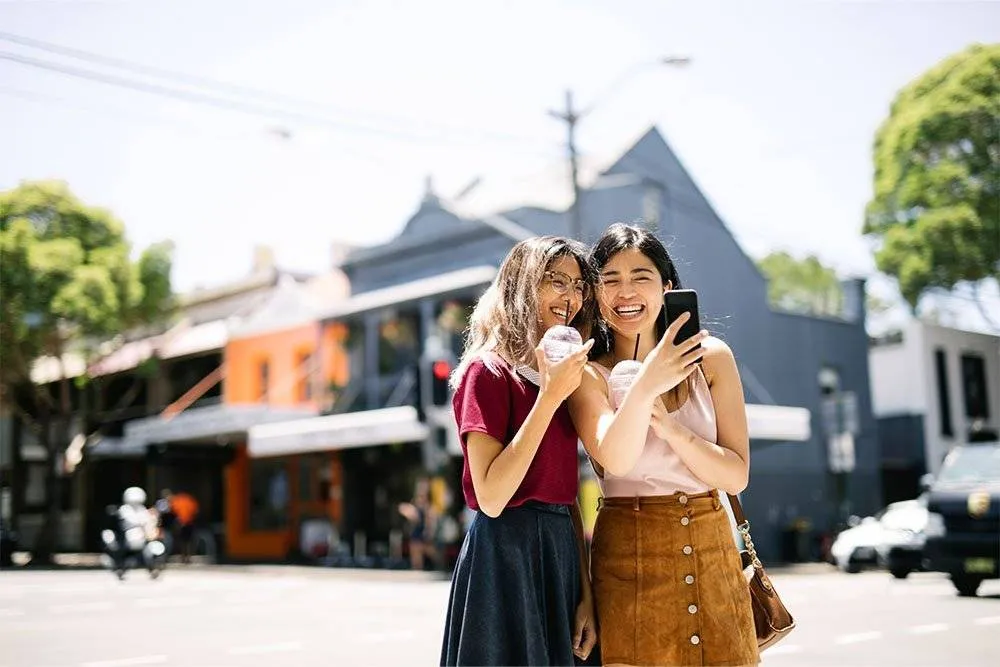 Two women with milkshakes, taking a selfie in Surry Hills — iStock