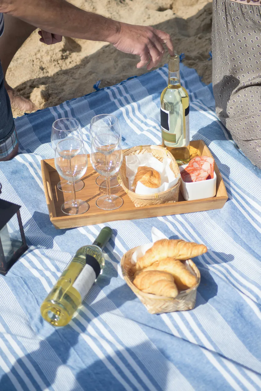 picnic at the beach with bread, croissants, chorizo and wine