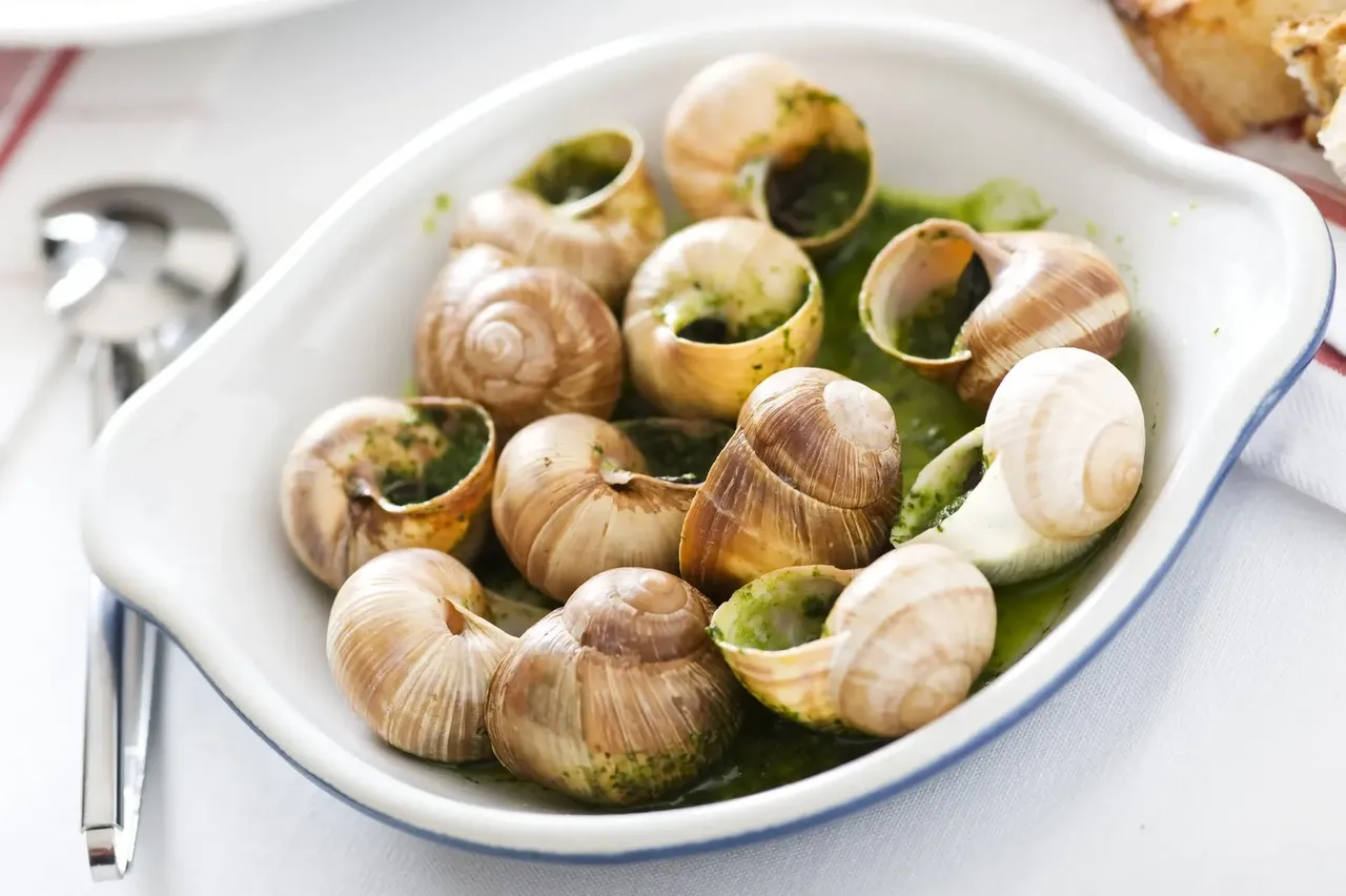 A close-up of escargot dishes at L’Escargot Bar, featuring snails in their shells with herbs and garlic butter.