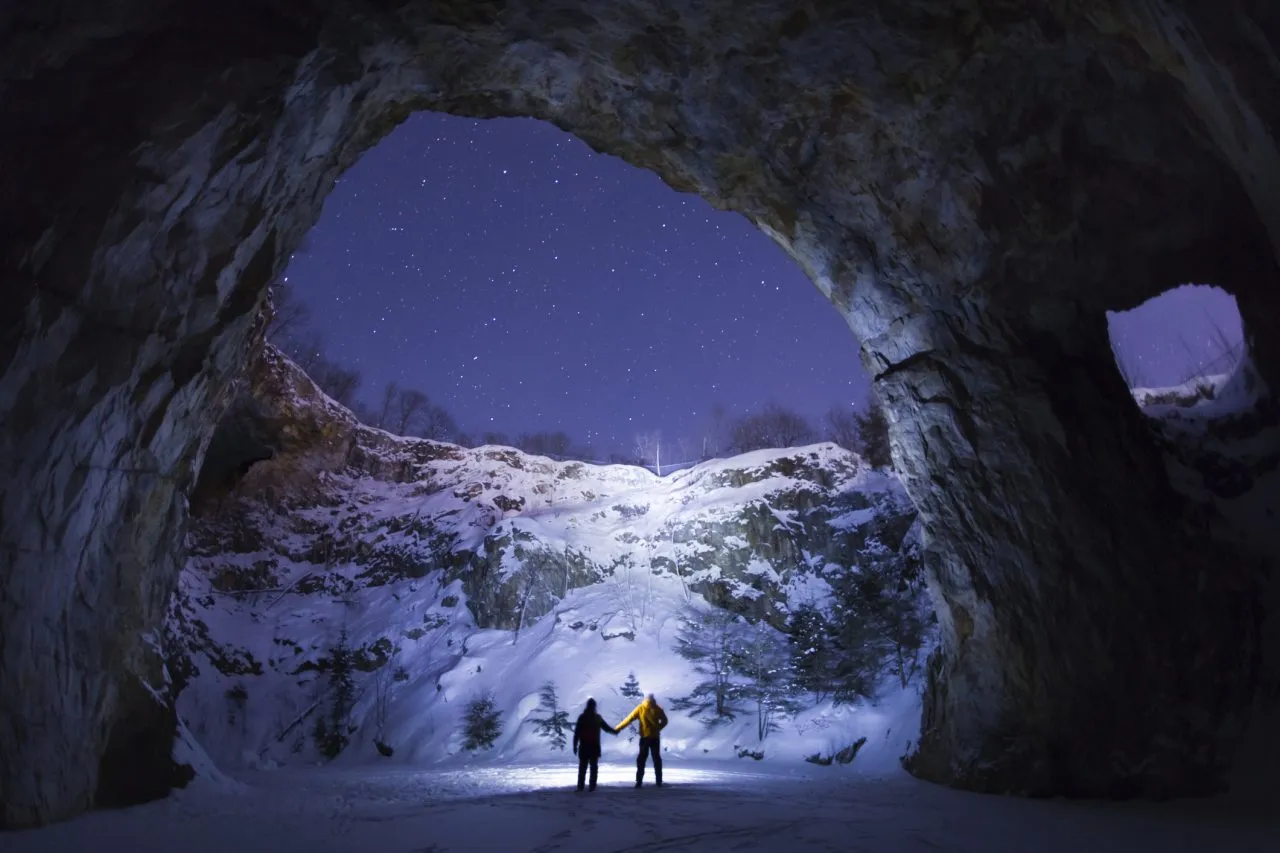Two people holding hands in an an underground cavern, Wallingford Back Mine, Quebec, Canada